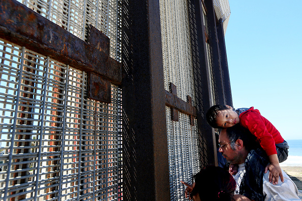 People visit loved ones by communicating through the U.S.-Mexico border fence at Friendship Park in San Ysidro, CA on Sunday, April 6, 2014. Many deported families and friends visit each other, mainly on weekends, at the park after being separated by immigration officials. (Photo by Sandy Huffaker/Corbis via Getty Images)